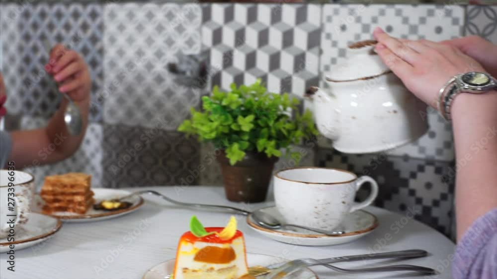 Portrait of cute caucasian girl with ponytails eating honey pie in coffee shop with her mother Portrait of cute caucasian girl with ponytails eating honey pie in coffee shop with her mother