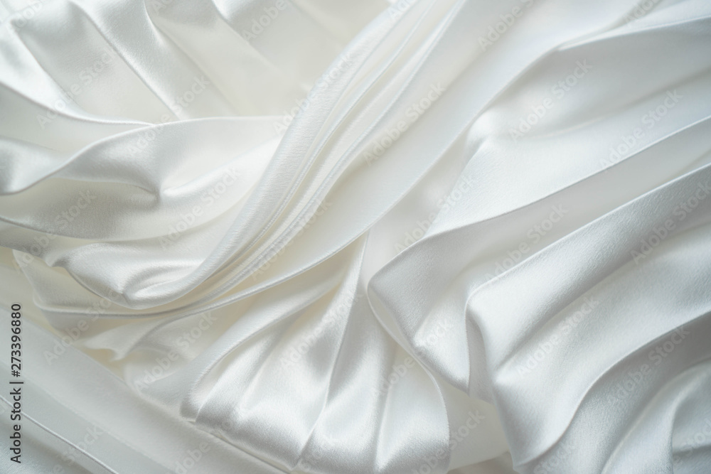 Obraz premium White silk or satin fabric folded background. Luxurious fabric fold glamour background. Tender elegant white silk background use for cosmetic store, spa salon. Wedding, Christmas, New Year design