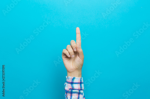 Person pointing at something on a blue background