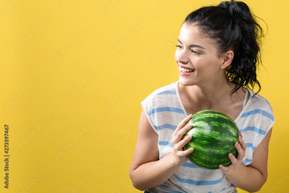 Young woman holding watermelon on a solid background Young woman holding watermelon on a solid background