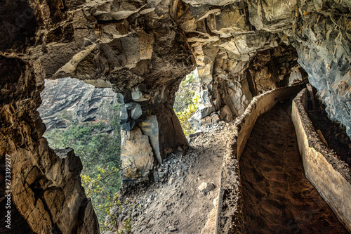 An old aqueduct now used as an adventure hiking trail Guimar valley. Trail in the fog through the mysterious mountains and caves. Tenerife, Spain