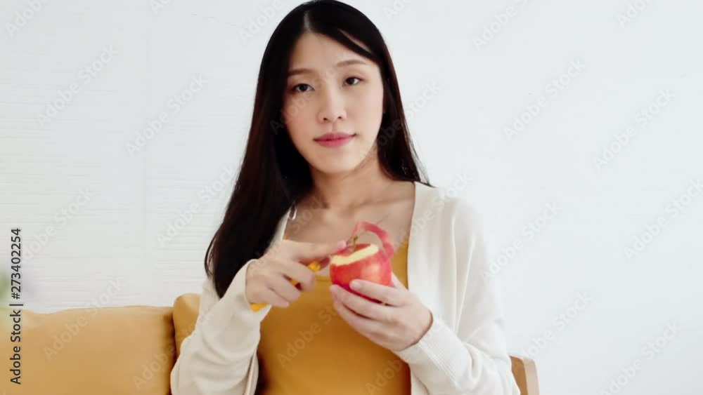Asian women are peeling red apples. Which is part the pesticide residue But the nutrient value is still rich, whether it is various vitamins That helps nourish health of the mother and unborn child Asian women are peeling red apples. Which is part the pesticide residue But the nutrient value is still rich, whether it is various vitamins That helps nourish health of the mother and unborn child
