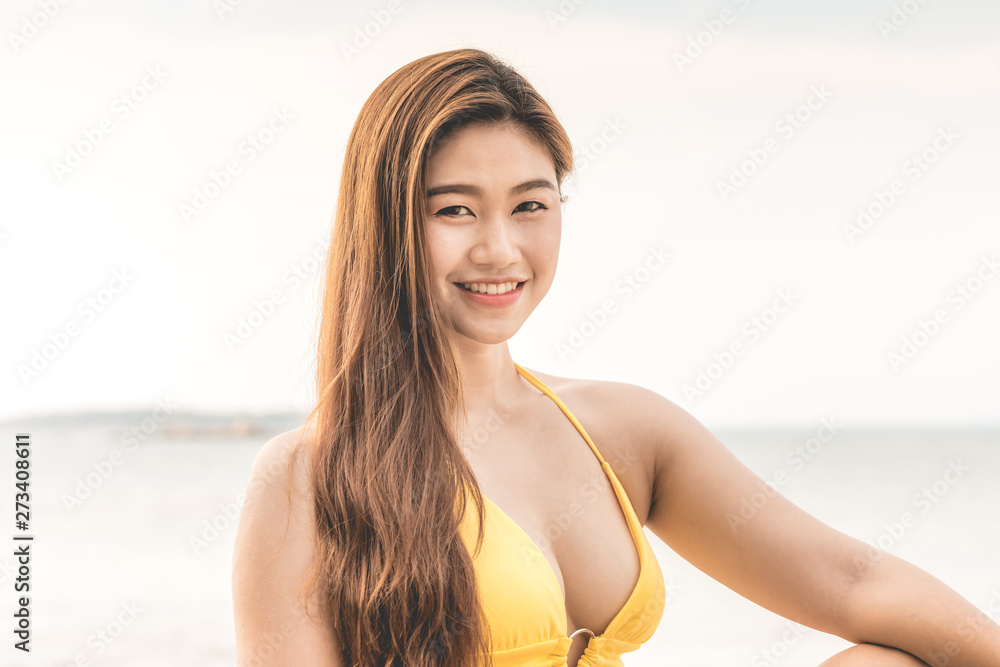 Attractive Asian young woman wearing bikini smile enjoy with summer vacation on the beach feeling so happiness and cheerful,Travel in tropical beach in Thailand,vacations and relaxation Concept