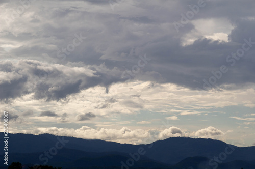 The Dark gray dramatic sky with large clouds on mountain in rainy seasons. © scentrio