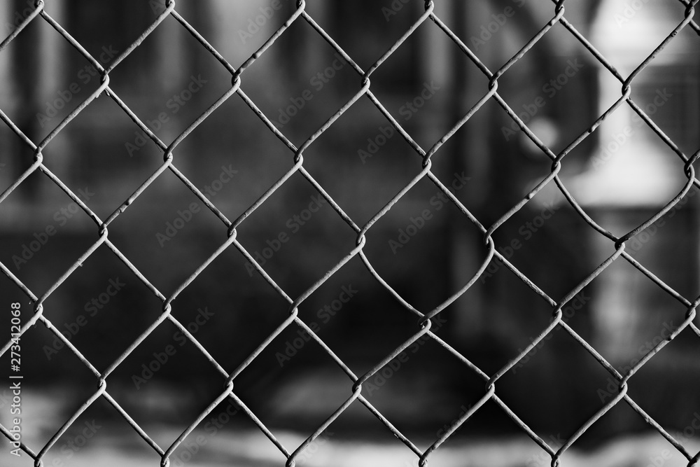 Fototapeta premium Metal grid fence on a dark background