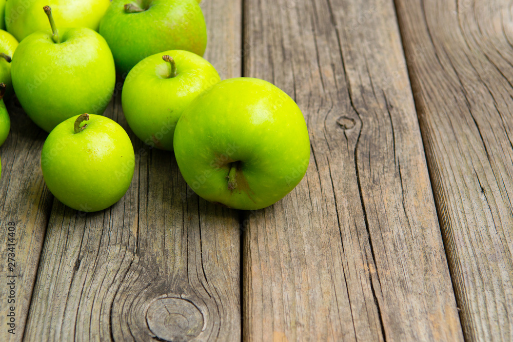 green apples on old wooden background green apples on old wooden background