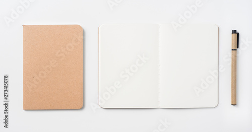 Top view of hardcover kraft notebook and pen