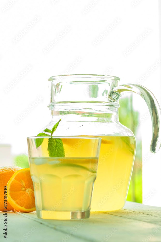 Jug and glass with lemonade on wooden table. Jug and glass with lemonade on wooden table.
