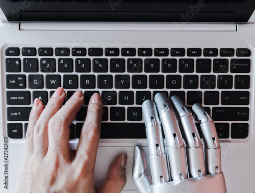 Robot hands and fingers point to laptop button advisor chatbot robotic artificial intelligence concept photo