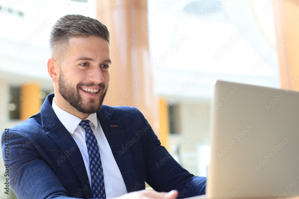 Portrait of young man sitting at his desk in the office. Portrait of young man sitting at his desk in the office.