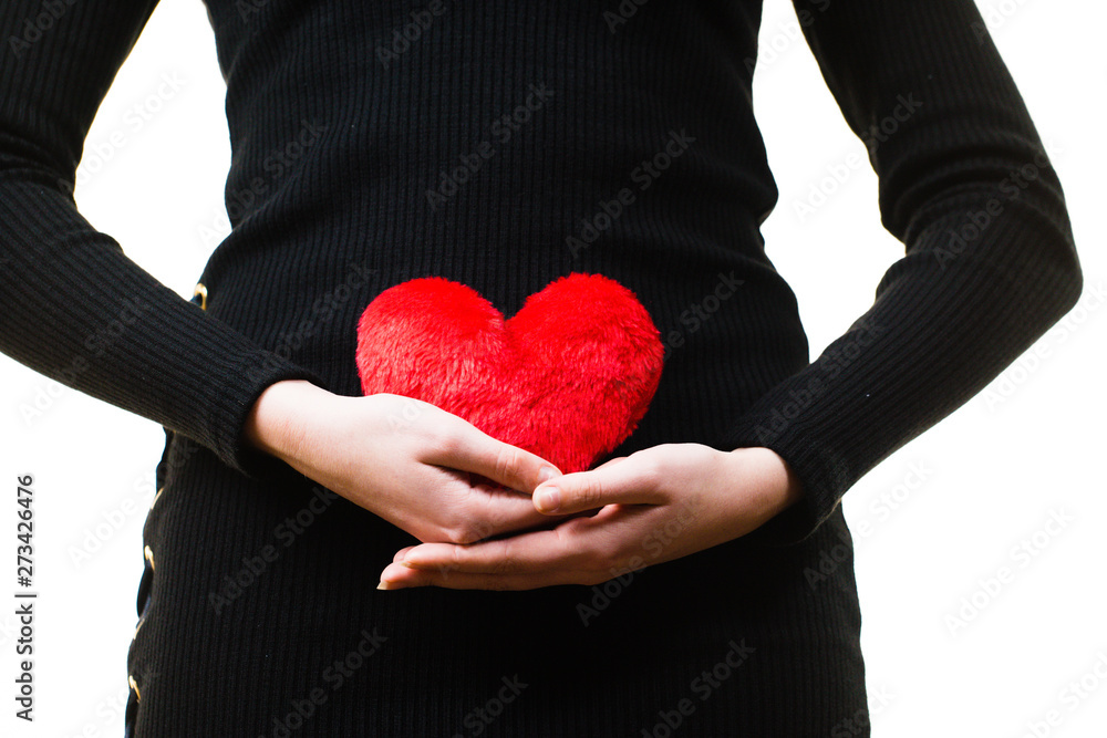Woman expecting baby with heart pillow Woman expecting baby with heart pillow