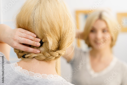 Woman in bathroom styling hair
