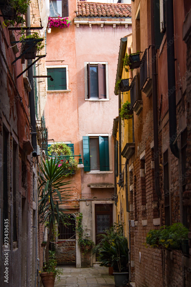 Corner of a traditional Venetian street on a bright sunny day. Cityscape. Architecture and landmark of Venice, Italy.