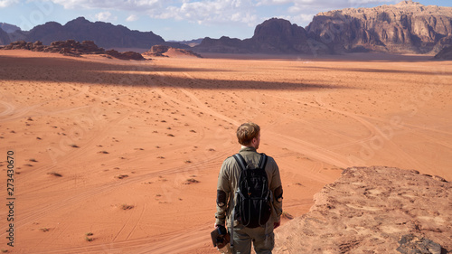 Man travel in Wadi Rum desert with a red sand dunes. Located in Jordan.