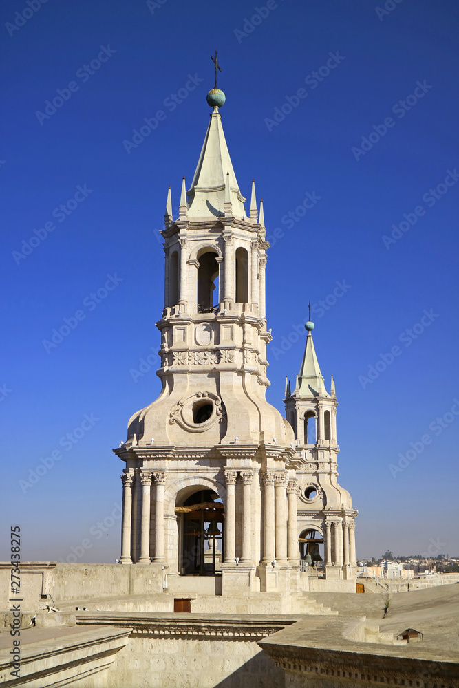 Stunning white volcanic stone bell tower of Basilica Cathedral of Arequipa against vibrant blue sky, Arequipa, Peru