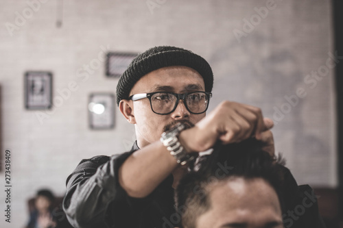 Portrait of barber hairstyle a costumer hair with hand and pomade in barbershop or salon