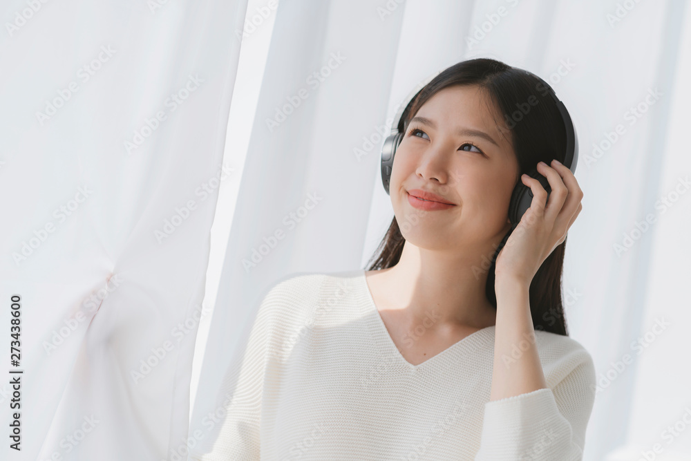 relex and peaceful asian woman enjoy weekend with music headphone morning sunlight near window home background relex and peaceful asian woman enjoy weekend with music headphone morning sunlight near window home background