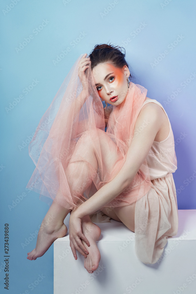 Fashion portrait of woman bright red makeup, curly hair and light summer dress. Girl with perfect art make up on a colored background Fashion portrait of woman bright red makeup, curly hair and light summer dress. Girl with perfect art make up on a colored background