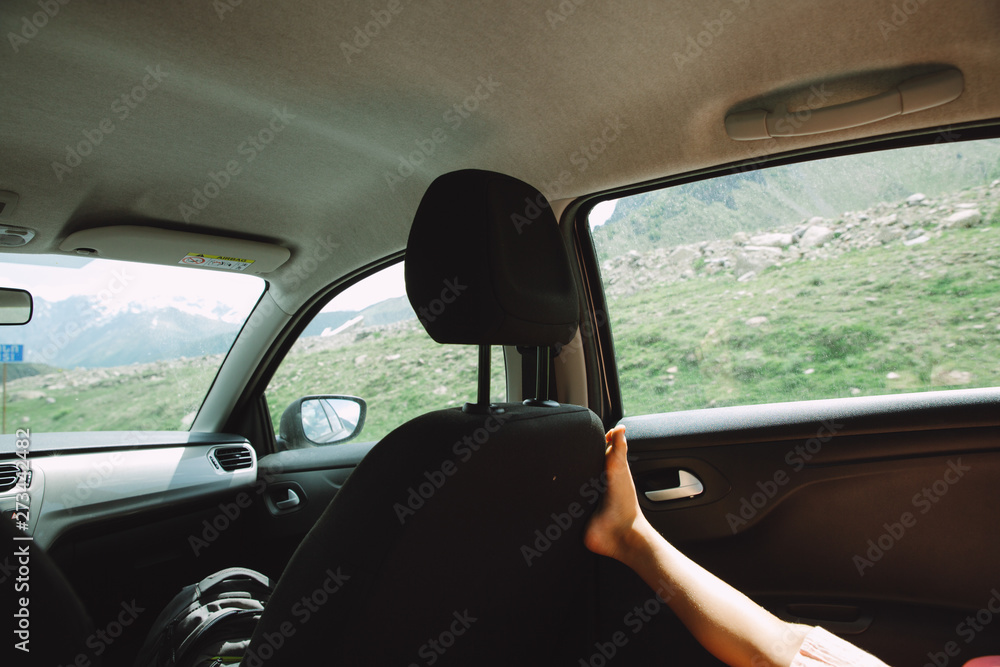 Leg of a girl travelling in the car and enjoying the landscape of Georgian mountains Leg of a girl travelling in the car and enjoying the landscape of Georgian mountains