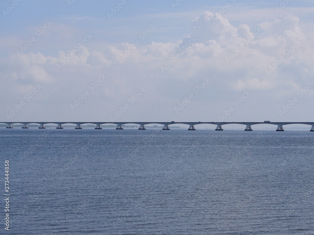 Obraz premium long bridge in the rivers Rhine, Maas delta in the Netherlands, called Zeelandbrug, near the small town Colijnsplaat on the island Beveland at the estuary Oosterschelde
