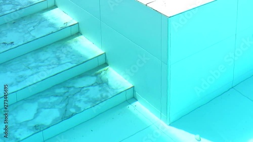 marble stair of swimming pool and wall tide under aqua color water photo