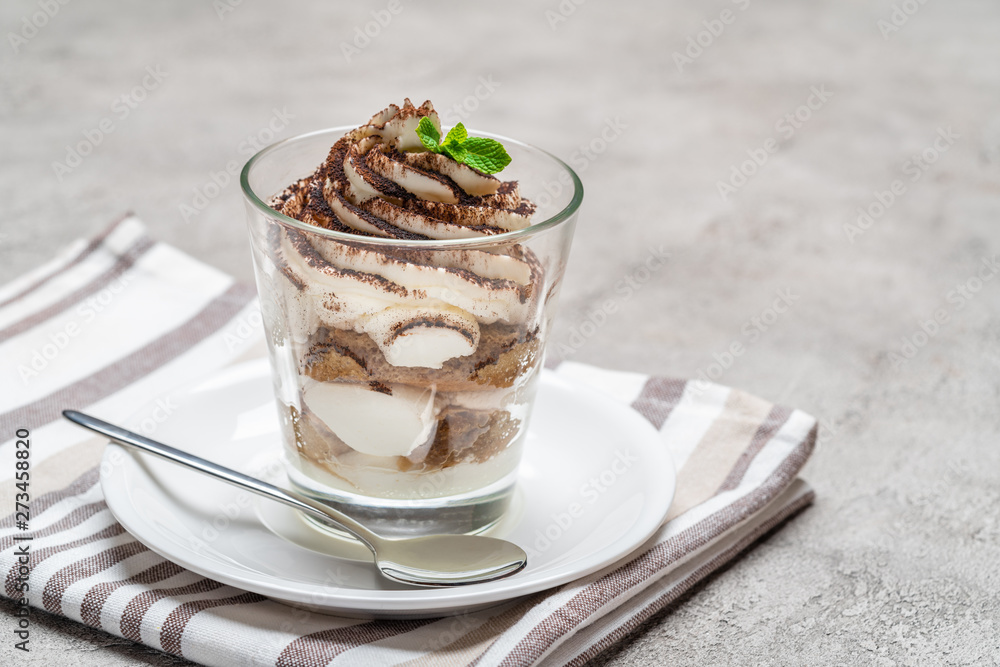 Classic tiramisu dessert in a glass on concrete background Classic tiramisu dessert in a glass on concrete background