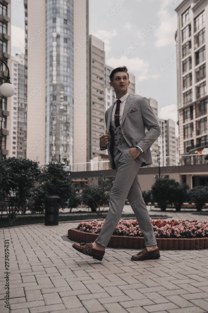 Businessman young handsome in full suit walking on city street. Urban background. Stylish man model. Office manager. Success. Business concept Businessman young handsome in full suit walking on city street. Urban background. Stylish man model. Office manager. Success. Business concept