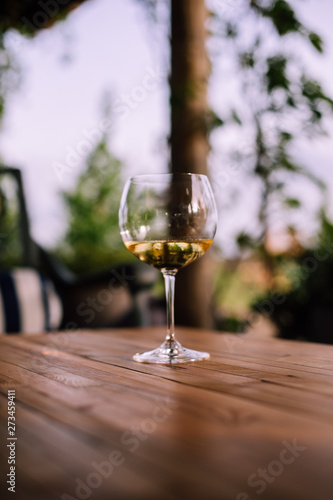 a glass of white wine on wooden table, blurred background