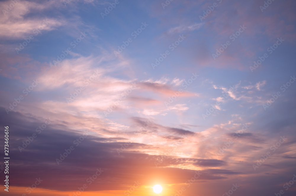 Sunset on the sky, bright sun and colorful clouds.