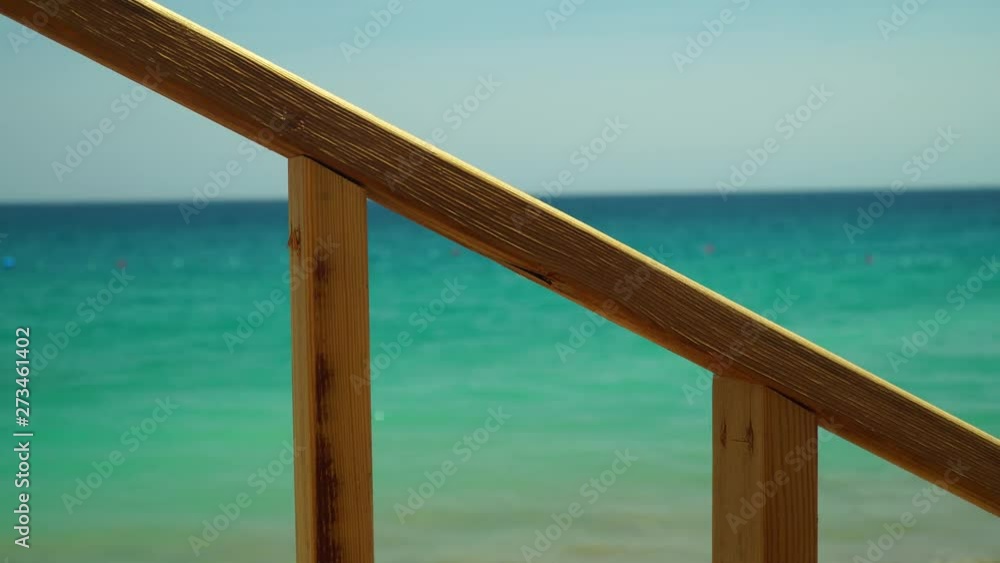 Wooden staircase handrails on the background of the sea. Wooden staircase handrails on the background of the sea.