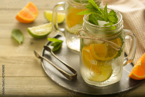 Homemade lemonade with lime, mint in a mason jar on a wooden rustic table. Summer drinks.