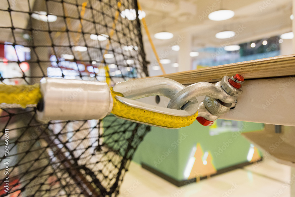 fastening a yellow nylon rope to a metal structure close-up. equipment in the obstacle course