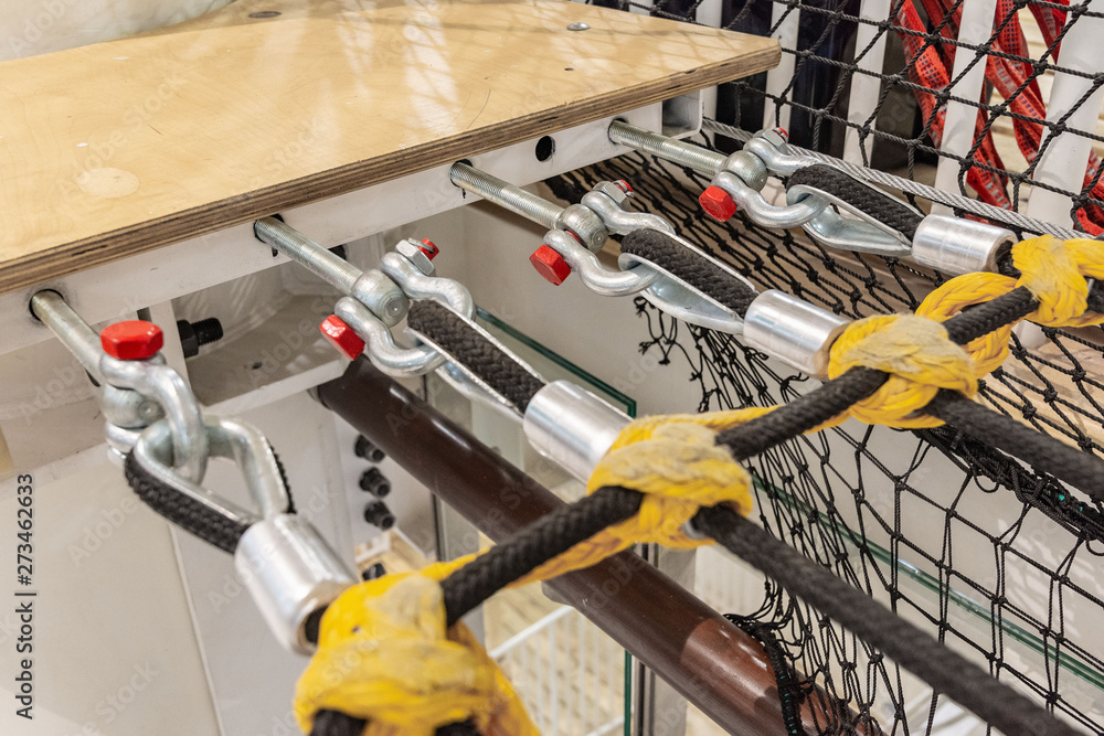 row of black nylon ropes attached to a metal structure close-up. equipment in the obstacle course