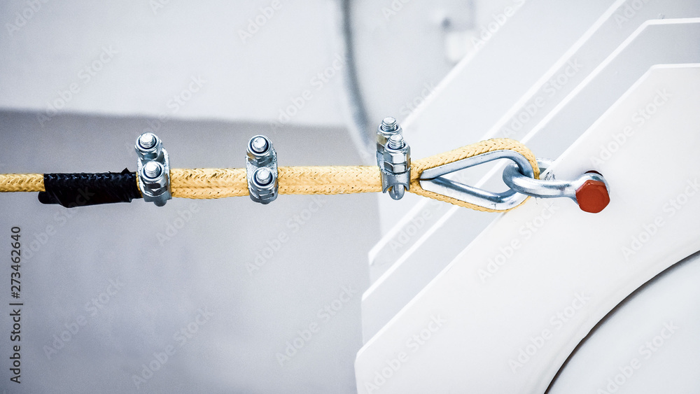 Close up of a yellow nylon rope fastening to a metal structure Close up of a yellow nylon rope fastening to a metal structure
