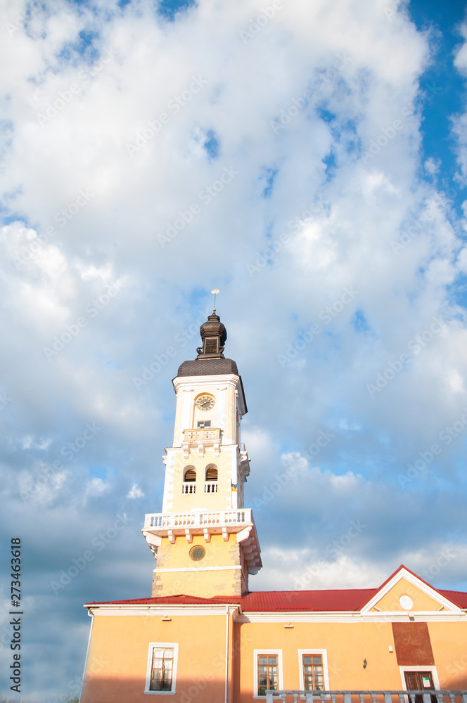 High old tower. The dome and spire of the temple against the blue sky and white clouds. Summer