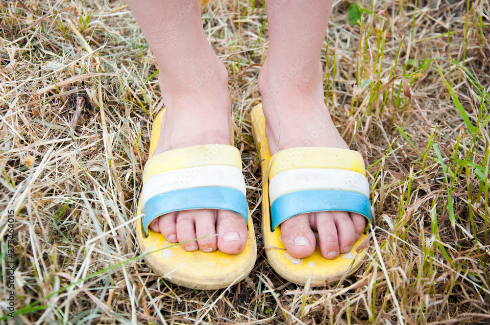 little girl in shorts and flipflops standing on the mown grass Stock