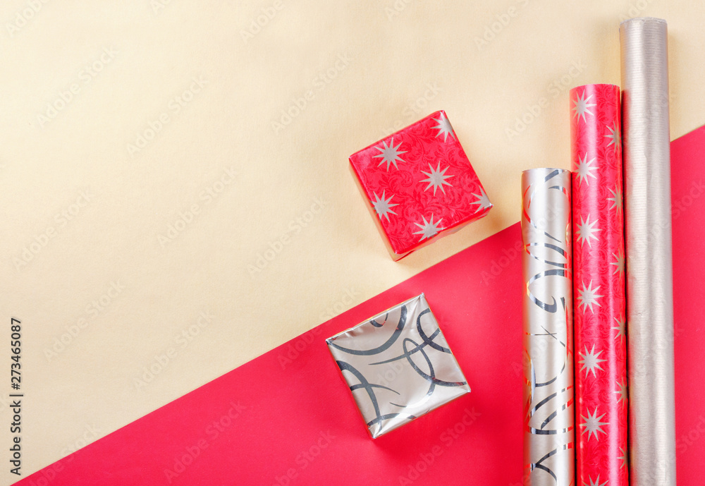 Fototapeta premium Golden gift boxes and red wrapping paper on bright background