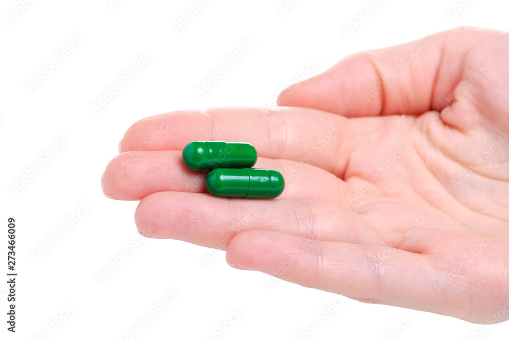 Green pills capcule medicine pharmasy in hand on white background isolation