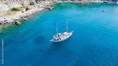 Aerial shot of beautiful blue lagoon at hot summer day with sailing boat and peopleon it. Top view.
