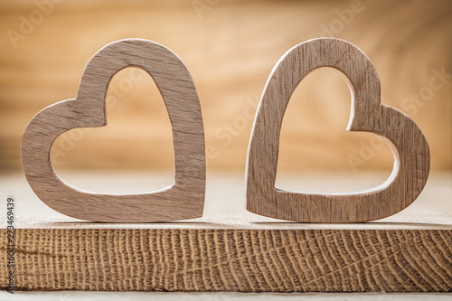 two wooden  hearts on wood background close up view photo