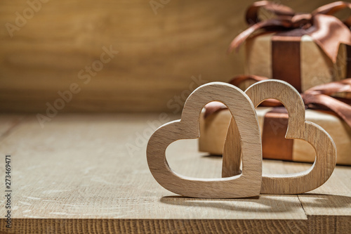 wood hearts and gift boxes close up wooden background photo