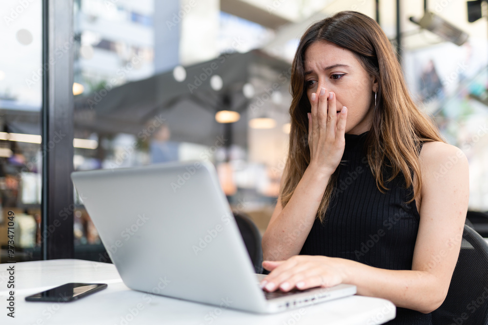 Business woman work process concept. Shocked female freelancer stares at laptop computer with bugged eyes, Blurred background, film effect. Business woman work process concept. Shocked female freelancer stares at laptop computer with bugged eyes, Blurred background, film effect.
