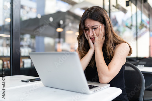 Business woman work process concept. Shocked female freelancer stares at laptop computer with bugged eyes, Blurred background, film effect. photo