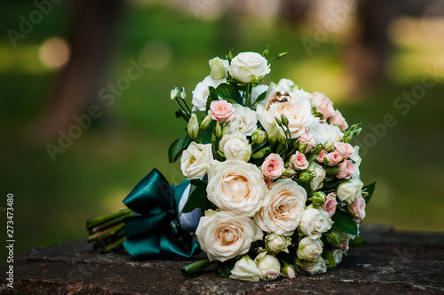 Gold wedding rings on the pink bouquet of flowers