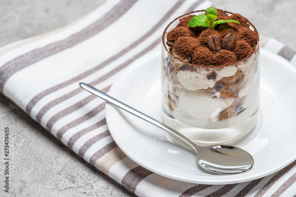 Classic tiramisu dessert in a glass on concrete background Classic tiramisu dessert in a glass on concrete background