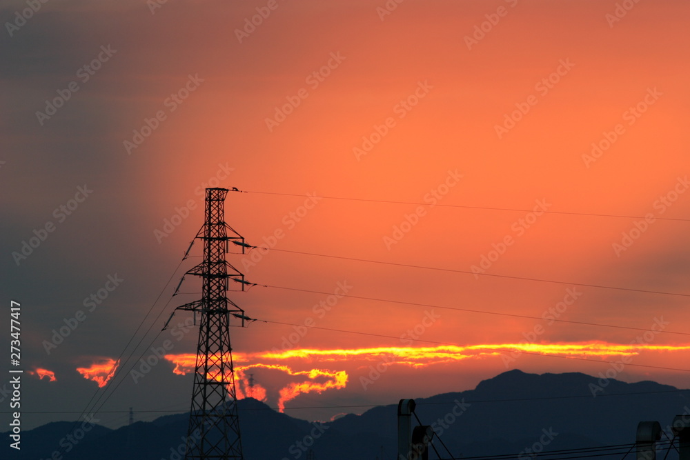 綺麗な夕焼けの空と送電線のタワー