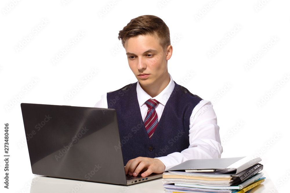 Young pensive businessman calculates taxes at desk in office. Isolated on white Young pensive businessman calculates taxes at desk in office. Isolated on white