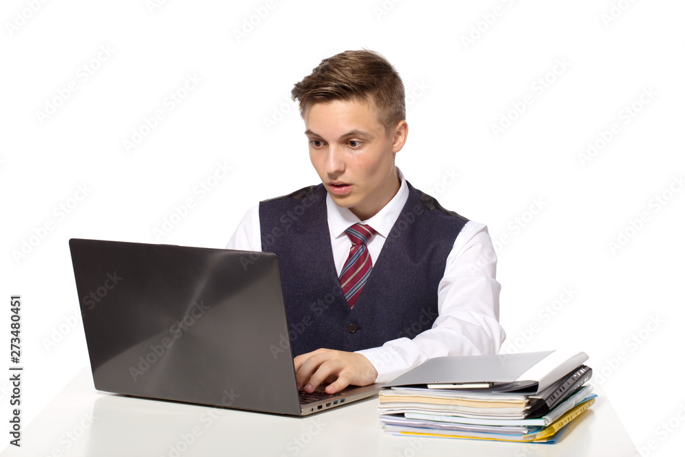 Young shocked businessman calculates taxes at desk in office. Isolated on white Young shocked businessman calculates taxes at desk in office. Isolated on white