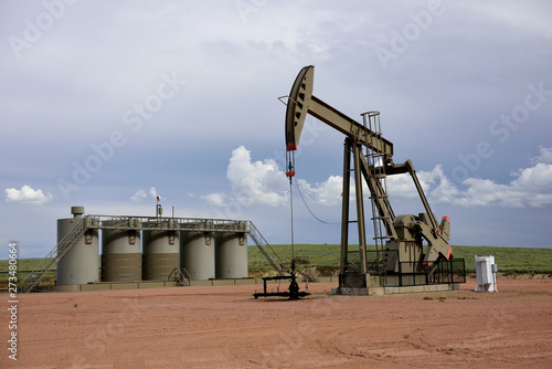 Crude oil well site pump jack and production storage tanks in the Niobrara shale of Wyoming.	 photo