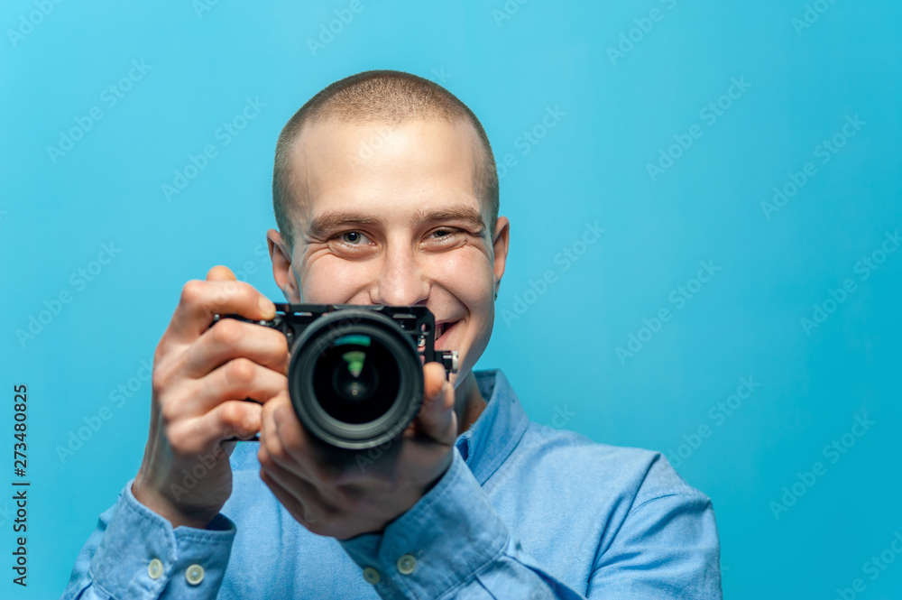 Portrait of positive young male photographer holding camera Portrait of positive young male photographer holding camera